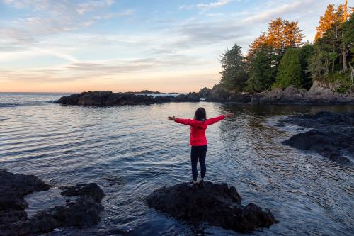 Girl Enjoying The View Of The Rocky Ocean Coast