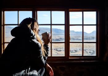 Woman Having A Cup Of Coffee While Admiring The Mountains